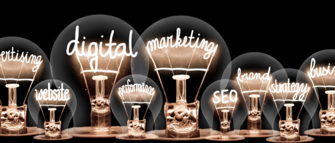 A line of large and small lightbulbs with marketing related terms inside of them, such as “SEO” and “strategy.”