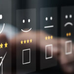 A business professional sitting at a desk with their laptop open. There is a customer review graphic above the laptop.
