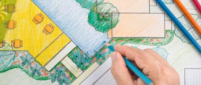 Colored landscape design plan showing pool, trees, patio areas, and drawing tools with pencils, rulers, and templates.