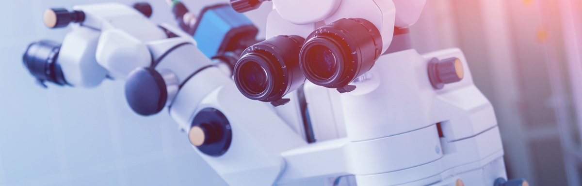 A close-up of medical equipment with dual eyepieces and adjustment knobs in a clinical eye care setting.A close-up of medical equipment with dual eyepieces and adjustment knobs in a clinical eye care setting.